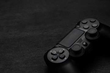 Wall Mural - Black gamepad on a dark wooden background