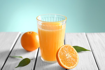 Wall Mural - Glass with fresh orange juice and fruit on wooden table