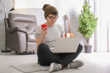 Wall Mural - Portrait of handsome hipster with laptop indoors