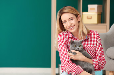 Wall Mural - Young woman with cute pet cat at home