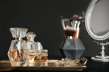 Wall Mural - Metal tray with perfume bottles on dark background