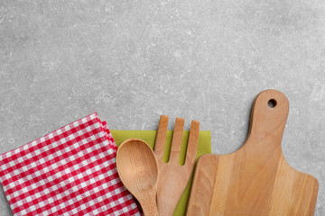 Canvas Print - Wooden cooking utensils and napkins on gray background, top view