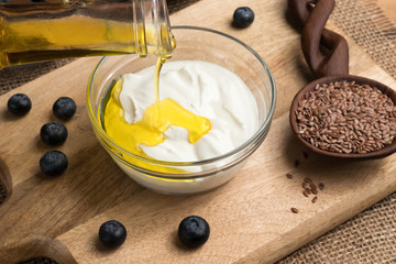 Wall Mural - Flax seed oil is being poured over cottage cheese in a bowl