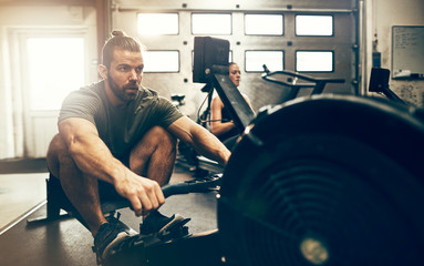 Wall Mural - Fit man working out during a gym rowing machine class