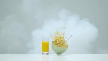 Bowl With Milk And Cereal And A Cup Of Orange Juice Exploding, Ultra Slow Motion 