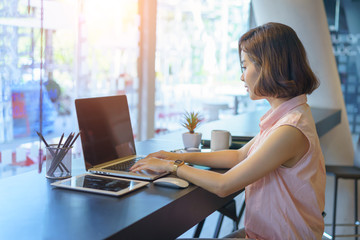 beautiful business woman working on desk with laptop in co working spaces.