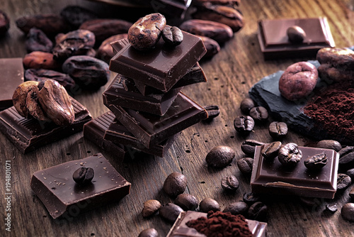 Plakat Broken ciemnej czekolady, kakao w proszku i ziaren kawy na drewnianym stole