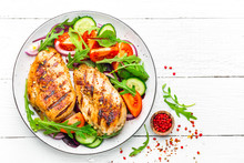 Grilled Chicken Breast. Fried Chicken Fillet And Fresh Vegetable Salad Of Tomatoes, Cucumbers And Arugula Leaves. Chicken Meat Salad. Healthy Food. Flat Lay. Top View. White Background