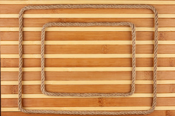 Two frame made of rope, lies on a background of a bamboo mat, with place for your text.