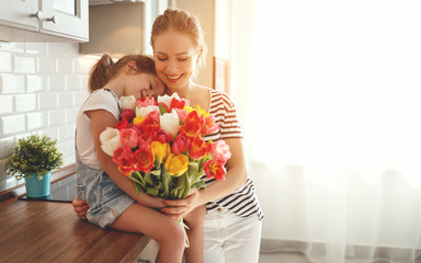 Wall Mural - happy mother's day! child daughter   gives mother a bouquet of flowers to tulips