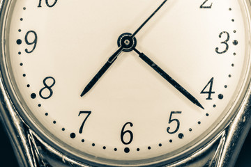 Closeup of clock face with hands, vintage filter