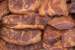 pile of cured ham on market display