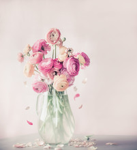 Pastel Color Ranunculus Flowers Bouquet With Falling Petals In Glass Vase On Table, Front View