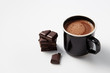 Black mug with hot chocolate served with chunks of dark chocolate