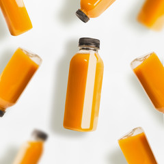 Yellow smoothie or juice bottles pattern on white background, top view, flat lay. Branding copy space