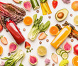 © VICUSCHKA - Red and yellow smoothie bottles with organic fruits and vegetables ingredients on white desk background, top view, flat lay. Healthy clean and detox, weight loss dieting or fasting  food concept