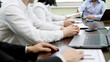© motortion - Company workers sitting at table at business meeting, listening to chief speech