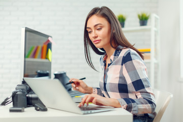 pretty young woman photographer with camera in office