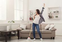 Happy Woman Cleaning Home With Mop And Having Fun