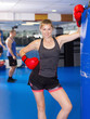 Portrait of young active woman  with punching bag