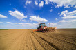 © oticki - Farmer seeding, sowing crops at field. Sowing is the process of planting seeds in the ground as part of the early spring time agricultural activities.