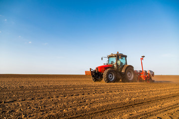 Farmer seeding, sowing crops at field. Sowing is the process of planting seeds in the ground as part of the early spring time agricultural activities.