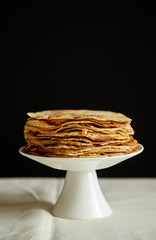 Wall Mural - Crepes cake with orange jam and honey on white cake stand. Pancake breakfast concept