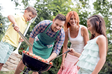 Wall Mural - Family cooking barbecue in park