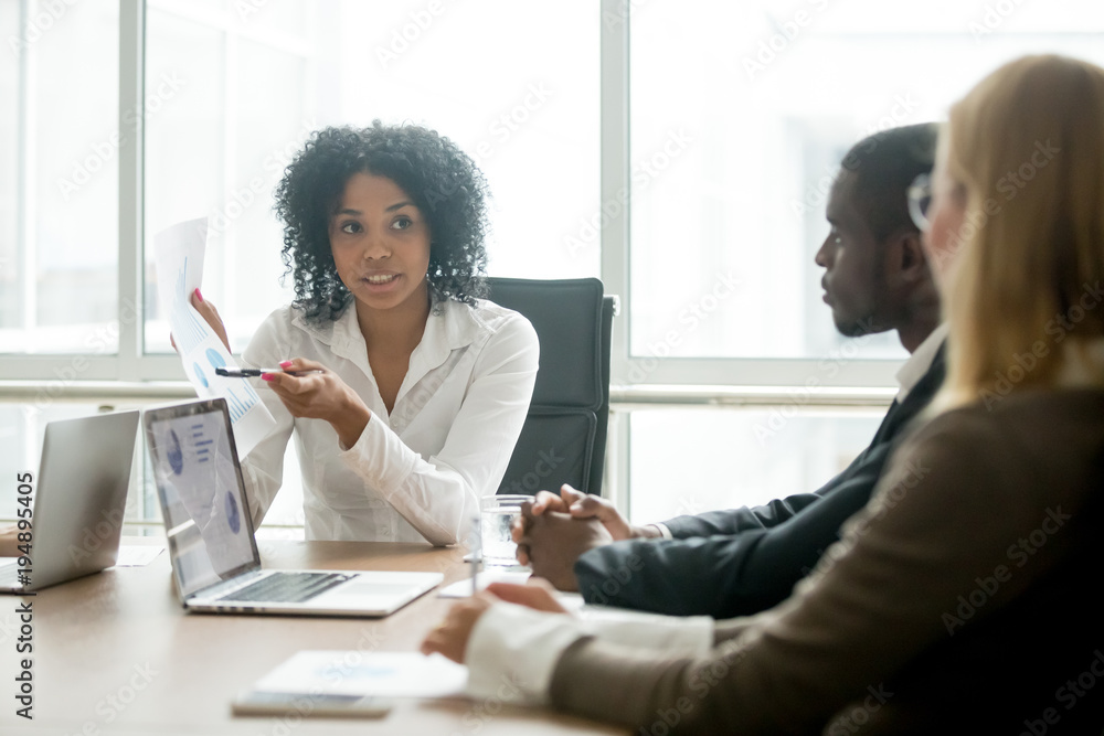 African businesswoman showing good statistics report explaining deal advantages convincing multiracial partners at negotiations meeting, black manager consulting diverse clients promising benefits - obrazy, fototapety, plakaty 