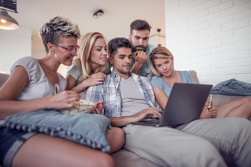 Wall Mural - Smiling  friends with laptop computer at home.