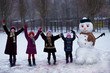 © Svetlana - A small cheerful girl near big funny snowman. A cute little girl has fun in winter park, wintertime