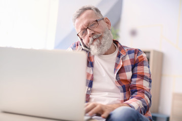 Canvas Print - Senior man talking on mobile phone while working in office