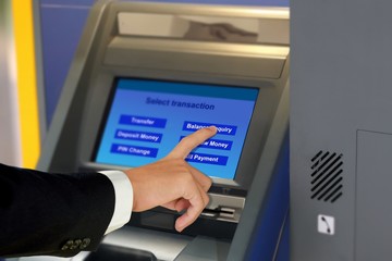 Hand touching display screen at ATM terminal