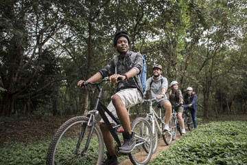 Group of friends ride mountain bike in the forest together