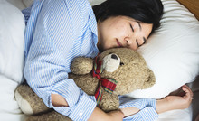 A Woman In Bed With A Teddy Bear