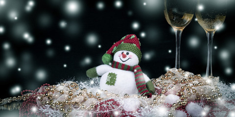 fun toy snowman and two glasses of champagne on a black backgro