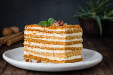 Slice of layered honey cake. Russian cake Medovik with walnuts. Horizontal, closeup view