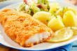 Crispy breaded fish with potatoes in close up