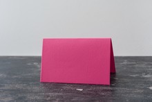 Pink Blank Card On Dark Table. Light Background