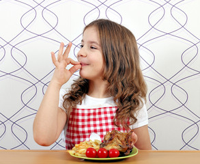 Wall Mural - happy little girl with roasted chicken wings and ok hand sign