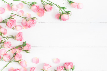 Wall Mural - Flowers composition. Frame made of pink rose flowers on white wooden background. Flat lay, top view, copy space