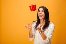 Portrait Of A Cheerful Young Woman Catching Small Gift Box
