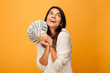 Portrait of a happy young woman holding money banknotes
