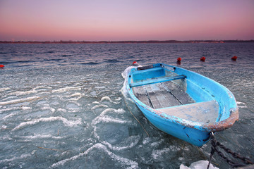 Canvas Print - blaues Holzboot eingefroren im See