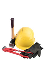 Yellow safety helmet with a sledgehammer with wooden handle, working gloves and adjustable plumbers wrench isolated on a white background, surface. Path saved, cut out. Construction equipment.