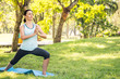 © ronnarong - Beautiful woman doing yoga exercises in the park. Concept of healthy lifestyle.