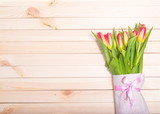 Fototapeta Tulipany - Fresh tulips on a background of light wooden boards