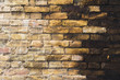 Textured background of old faded bricks stained with black oil. A brick gradient between dirty black and light yellow bricks. Grunge style