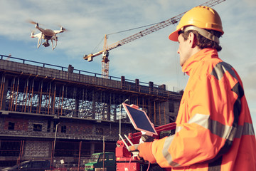 Wall Mural - drone operated by construction worker on building site