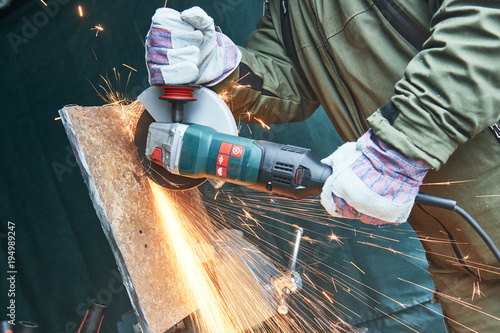 worker grinding cutting metal sheet with grinder machine and sparks Poster Mural XXL